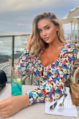 Very pretty blonde sitting at a restaurant table al fresco