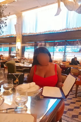 Busty and curvy ebony women in a restaurant looking through the menu