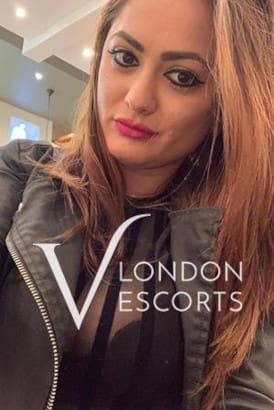 Dark haired escort with red lipstick and a see-through blouse in a selfie