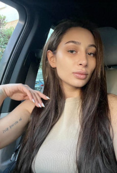 Girl with long brown hair taking a selfie in a car