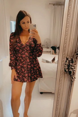 Slim brunette in a short summer dress taking a selfie photo